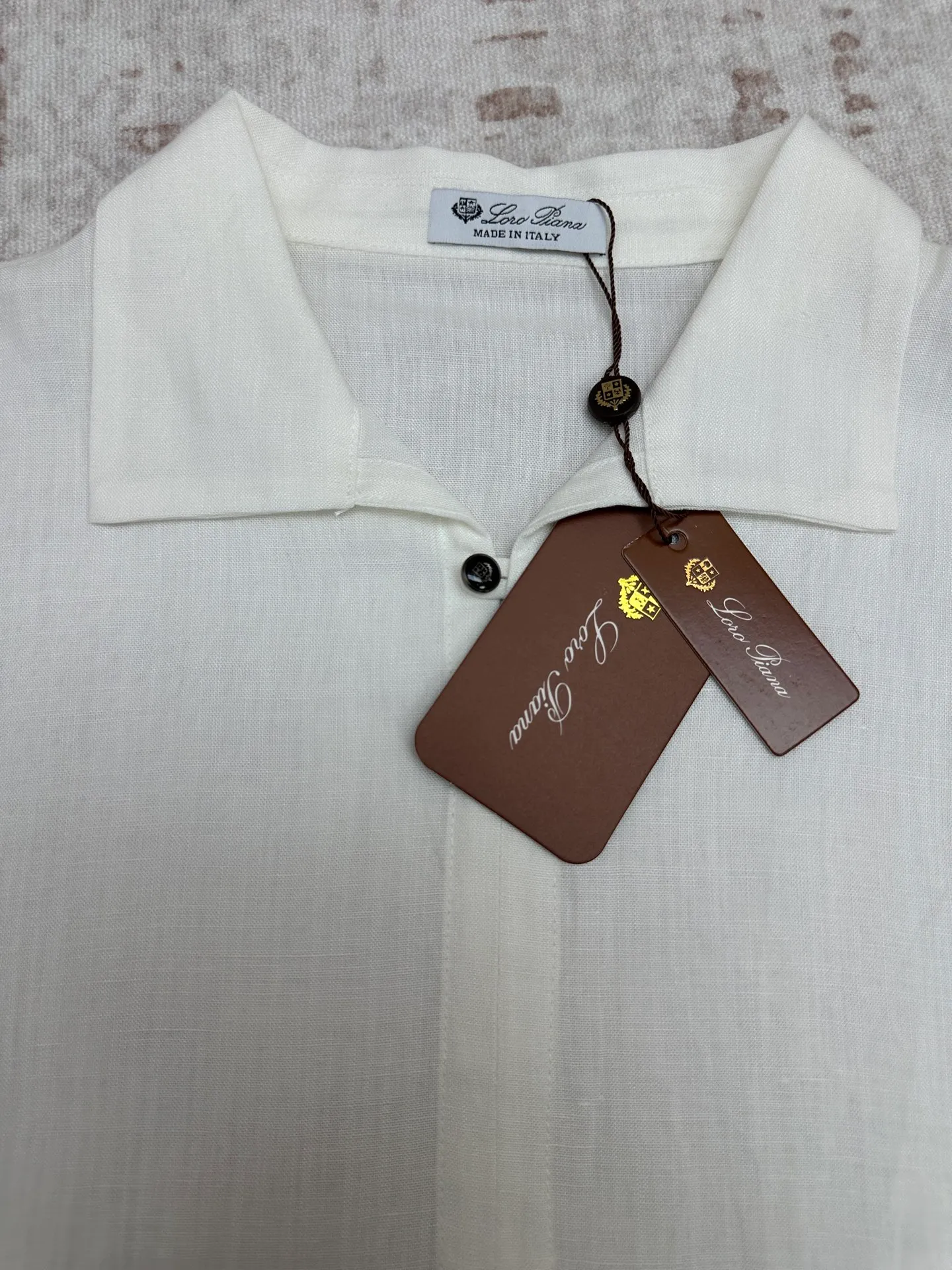 LP 26 New Arrival linen short-sleeved Polo shirt is a light luxury item made in Italy. It features a relaxed and elegant "old money style" tone, and uses simple design and natural fabrics to interpret the high-end feel of summer. The style adopts a Classic small lapel + single-button half placket design, which is neat and casual. It is matched with a slightly loose straight cut and a short-sleeved silhouette, taking into account comfort and neat lines. It does not flatter the body shape and hides the muscles to look slimmer. Available in navy blue and white, it is suitable for a variety of wearing scenarios, whether it is daily casual or light business occasions. The fabric is made of 100% linen, with natural texture and breathable holes. It has excellent moisture absorption and heat dissipation. It is dry and not sweaty when worn in summer, and has a natural drape when worn. It is an ideal choice for summer commuting and vacation. There is no unnecessary decoration on the whole, and the fabric texture and neat tailoring are the key to winning. It is low-key and durable, and can easily create an effortless high-end outfit. Sizes: M.L.XL.XXL.
